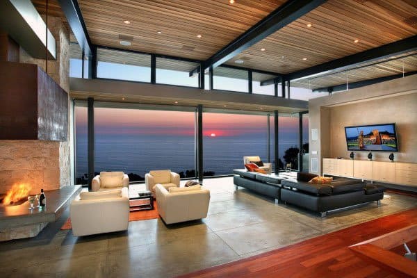 luxury living room gray tile floor white lounge chairs black sofa fireplace ocean view