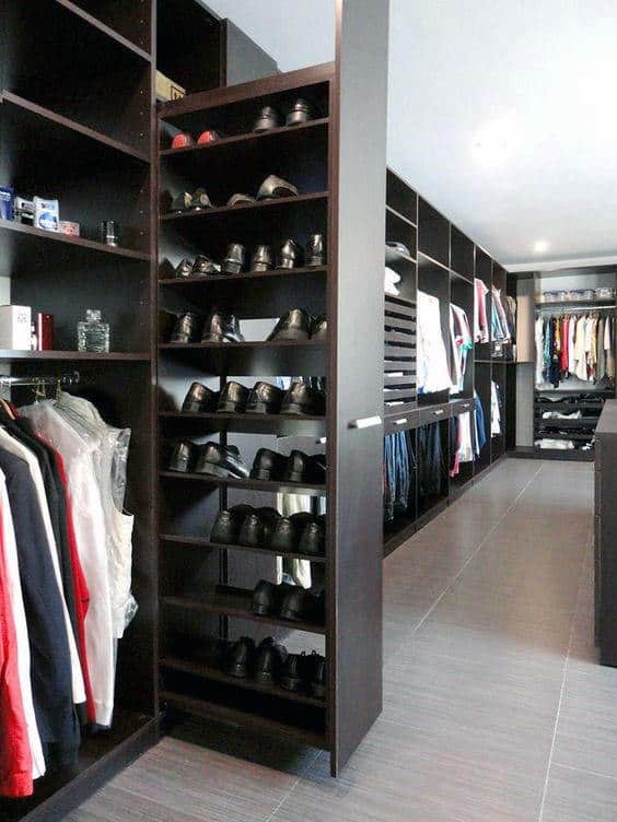 Spacious walk-in closet with neatly organized clothes, shoes on shelves, and open storage areas