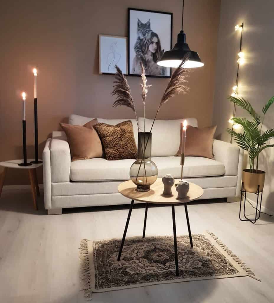 Cozy minimalist living room with a beige sofa, neutral tones, pampas grass decor, and soft ambient lighting