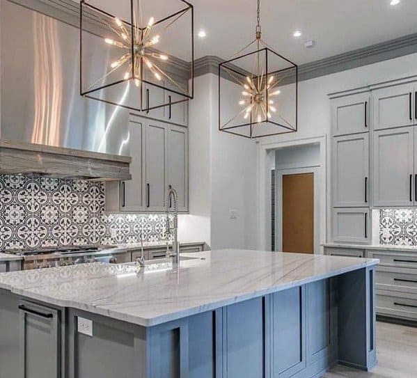 Modern kitchen featuring star-shaped pendant lights above a stylish island with marble countertop and gray cabinetry