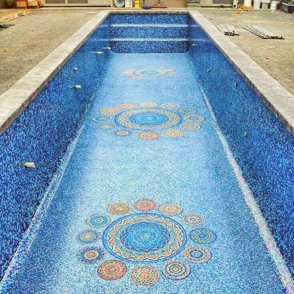 Empty swimming pool featuring colorful circular mosaic tile patterns on the floor.