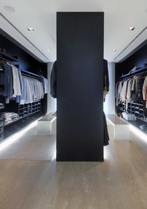 Modern walk-in closet with clothes neatly arranged on either side and a black partition in the center