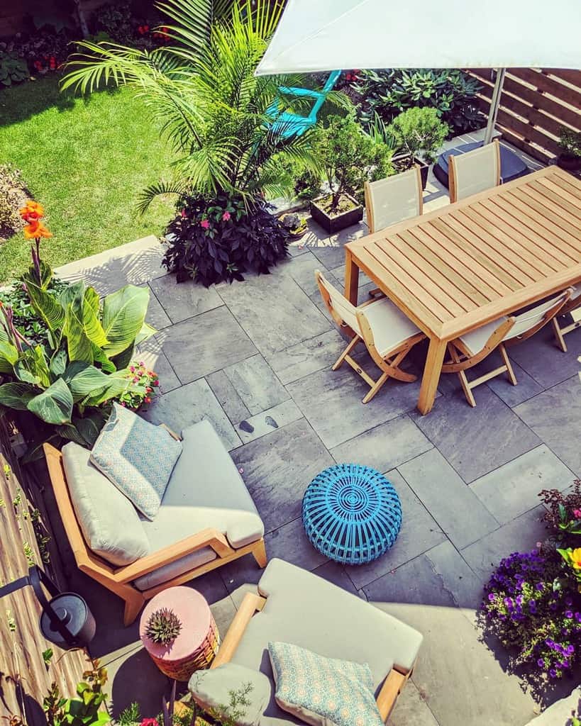 slate paver patio backyard with wood table and chairs 