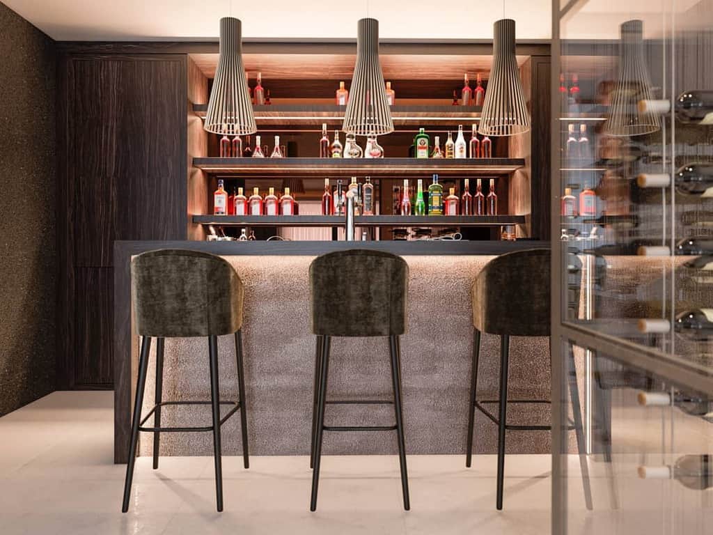 Modern basement bar with sleek shelves, velvet stools, pendant lights, and glass wine storage.