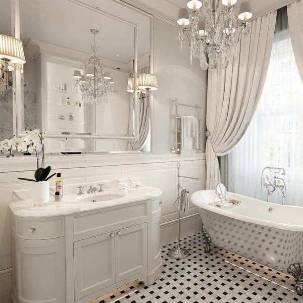 Elegant bathroom with chandelier, freestanding tub, and checkered tile floor.