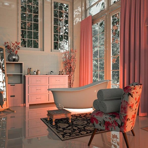 Elegant bathroom with freestanding tub, floral chair, and pink curtains filtering natural light.