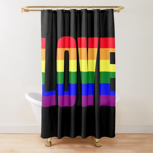 Black shower curtain with bold rainbow "LOVE" text in a bathroom featuring a clawfoot tub.