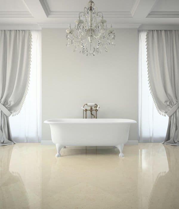 Elegant bathroom with freestanding tub, white draped curtains, and a crystal chandelier.