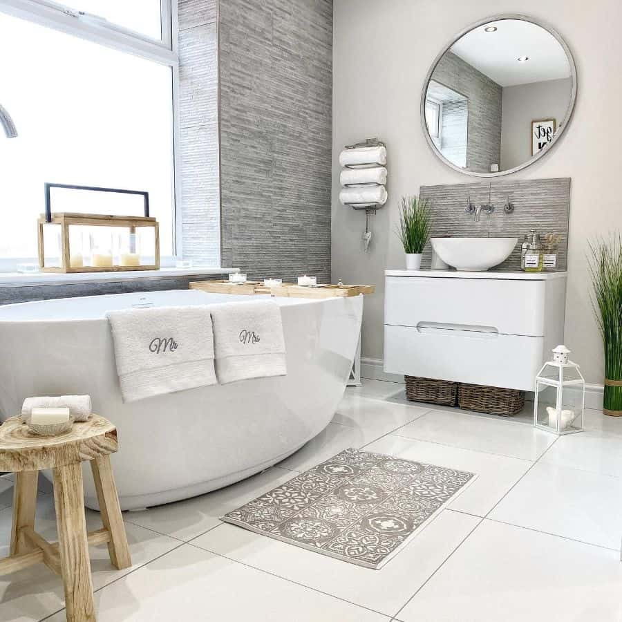 Bright bathroom with large freestanding bathtub, modern vanity, and decorative plants.