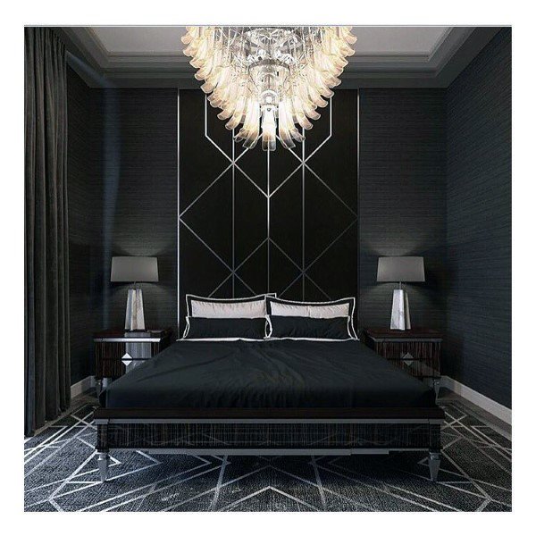 Luxurious black bedroom with geometric wall design, crystal chandelier, and modern decor.