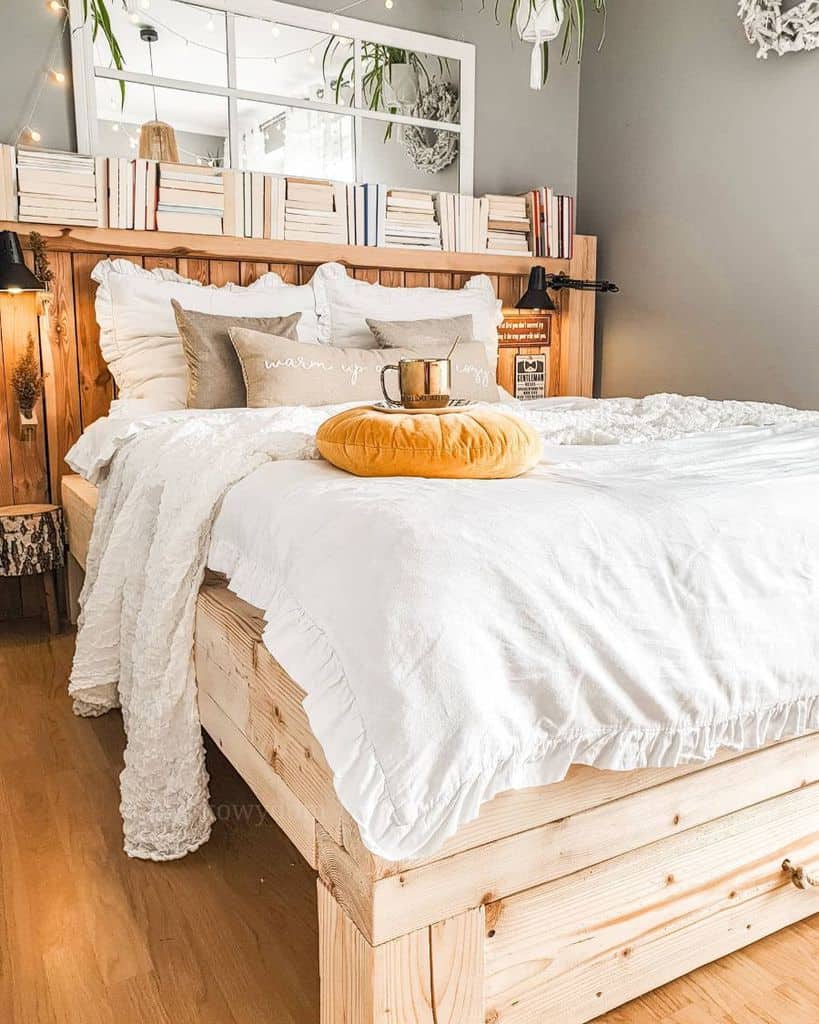 Cozy bedroom with rustic wood bed, headboard bookshelf, and layered pillows.