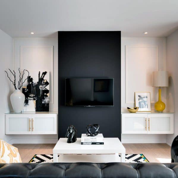 modern living room with black accent wall and white cabinets 