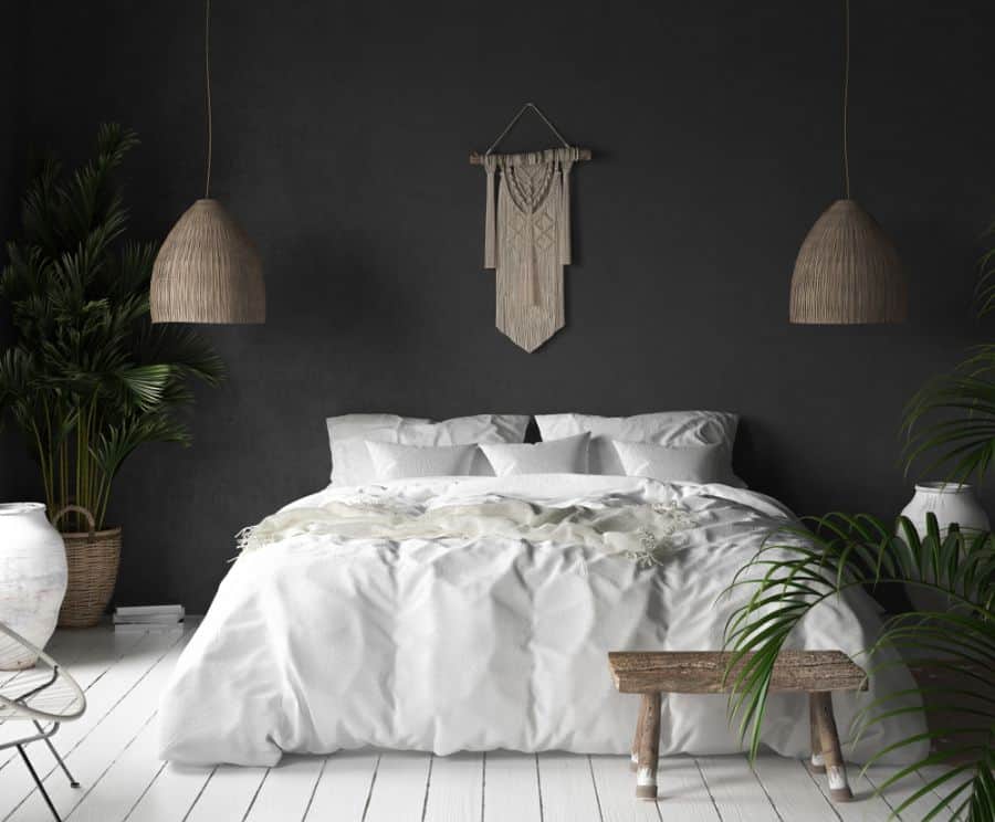 Modern bedroom with black accent wall, white bedding, and woven decor accents.