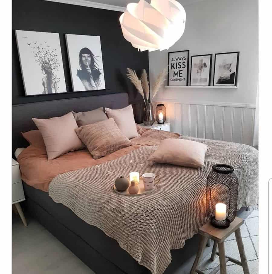 Cozy bedroom with black accent wall, beige bedding, and candle decor.