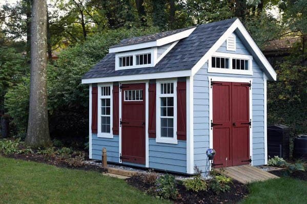 lue and red backyard shed with farmhouse-style doors and a shingled roof in a garden.