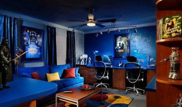 A sci-fi themed room with blue decor, posters, dual desks, and various science fiction memorabilia