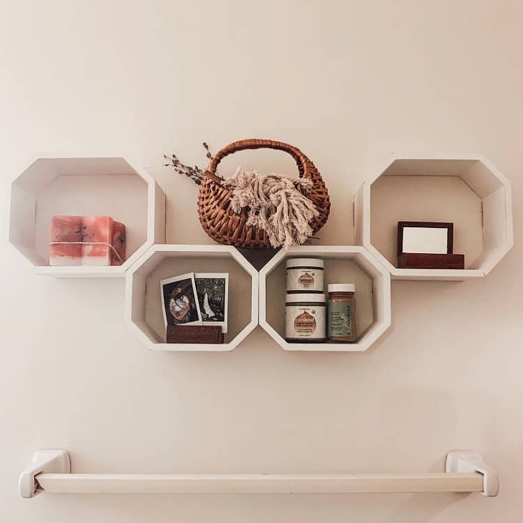 Octagon-shaped floating shelves with woven basket, candles, and small decor items.