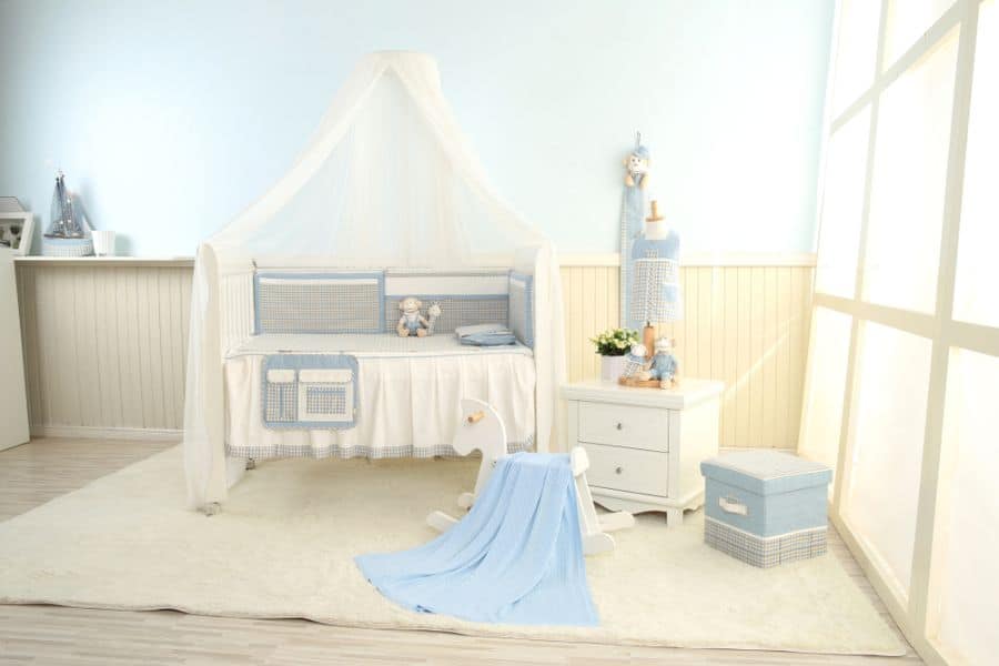 Soft blue baby boy's room with crib canopy, rocking horse, and gentle pastel accents.