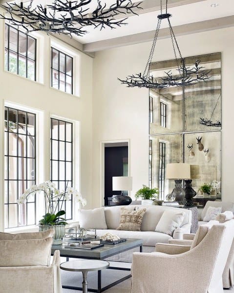 vaulted ceiling living room white sofas tree branch light fixtures large wall mirrors 