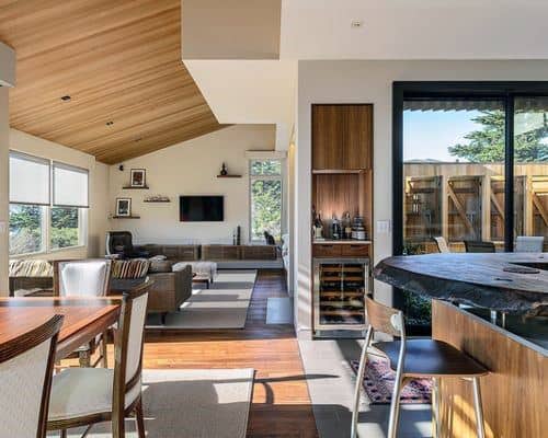 Open-concept living area with built-in wood mini bar, wine fridge, and modern furnishings.