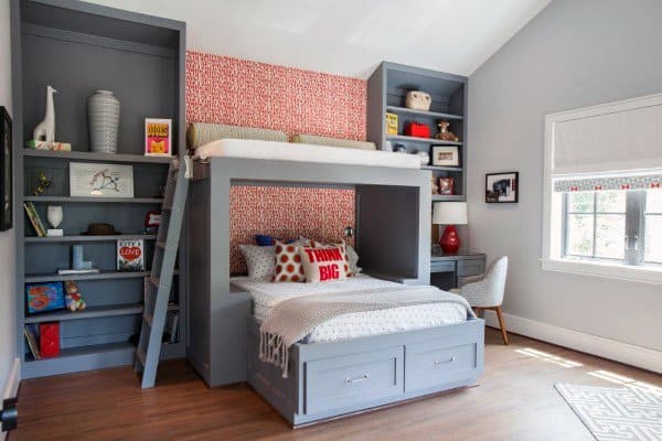 Lofted bed with seating below, built-in shelves, and a red accent wall.