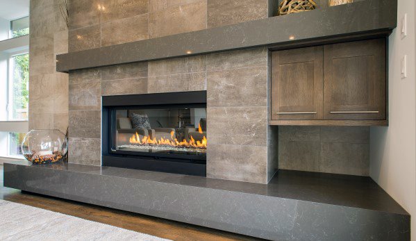 Contemporary gray stone fireplace with a linear gas insert and built-in wooden cabinet.