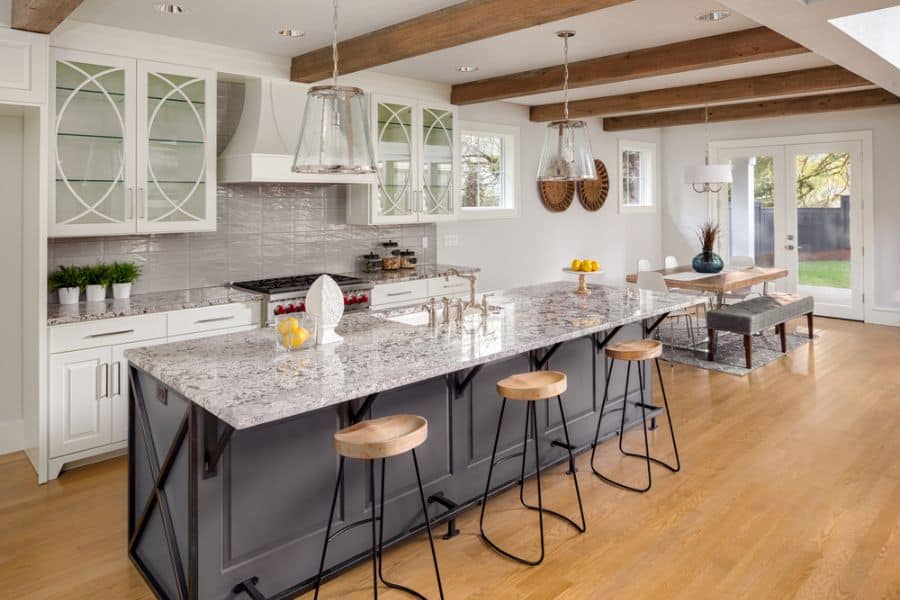 white cabinet kitchen with glass doors and gray island 