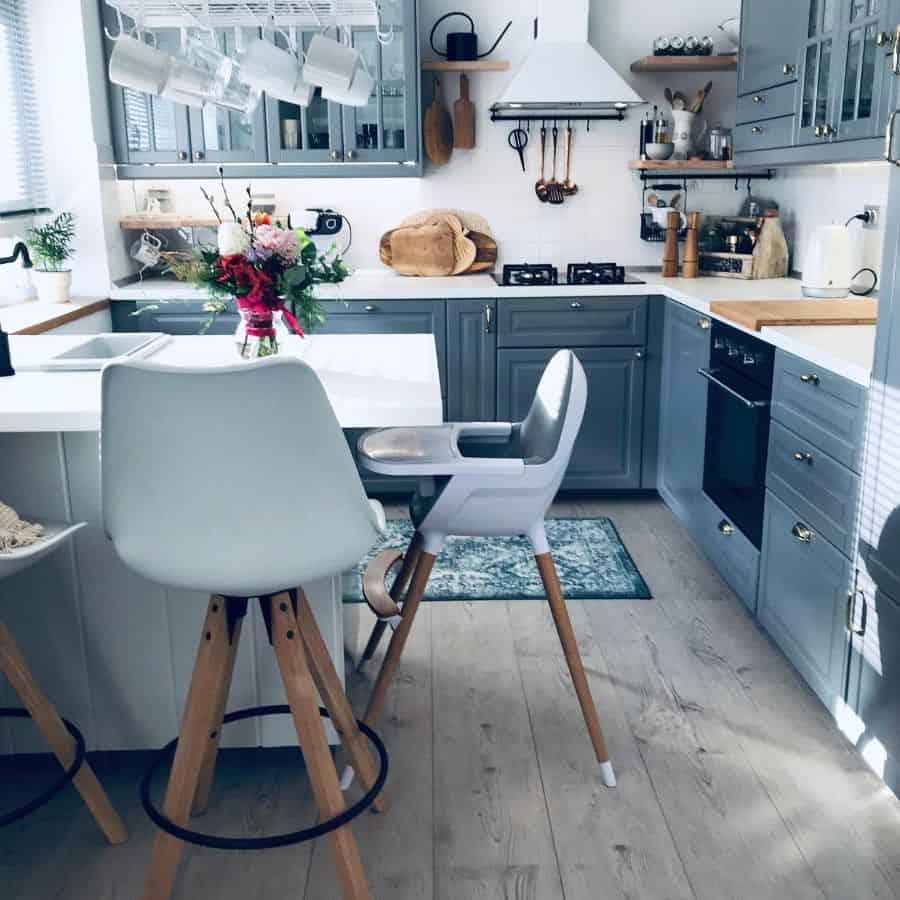 gray cabinet kitchen with white marble countertops and wood flooring