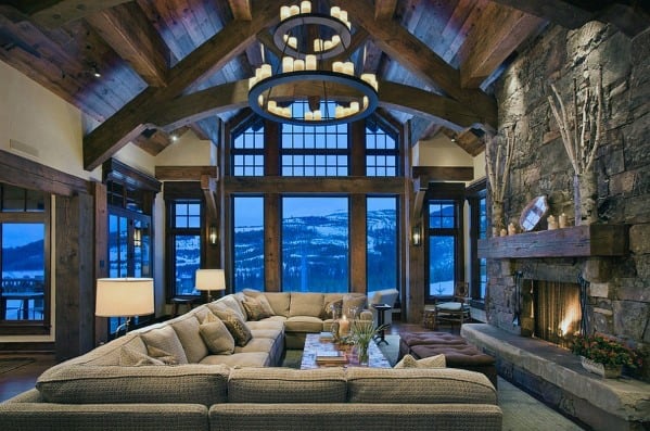 wood cabin luxury stone fireplace gray sofa 