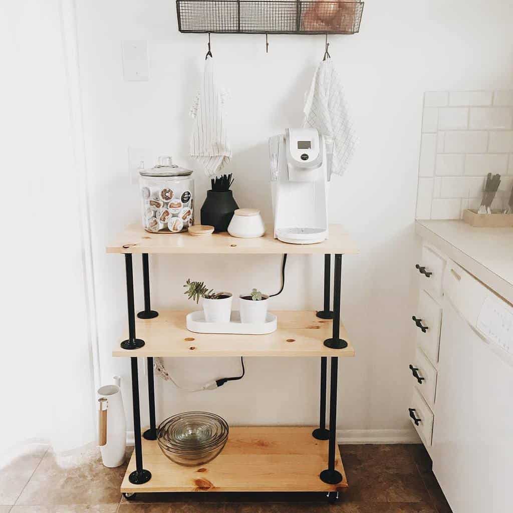 Minimalist kitchen bar cart with a white coffee maker, storage canister, and potted succulents.