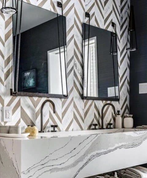 Bathroom with contemporary chevron tile backsplash, marble sink, and black fixtures.