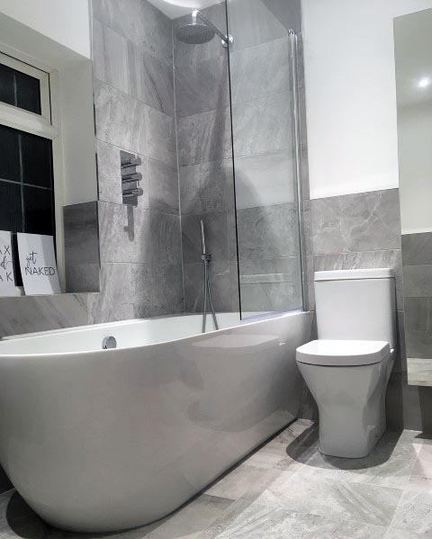 gray slate tile bathroom with white tub and toilet 