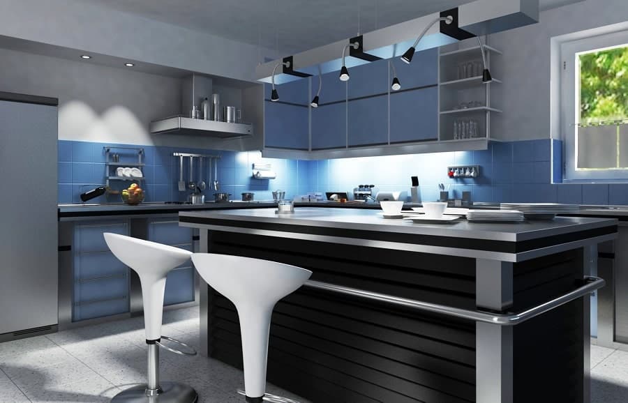 Modern kitchen with blue cabinets, a sleek black countertop island, bar stools, and chic hanging lights