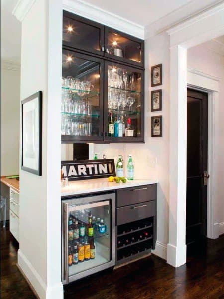 Modern mini bar with glass cabinets, wine rack, beverage fridge, and marble countertop.