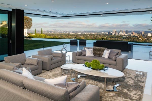 Contemporary living room with gray sofas, glass wall, and breathtaking city skyline views