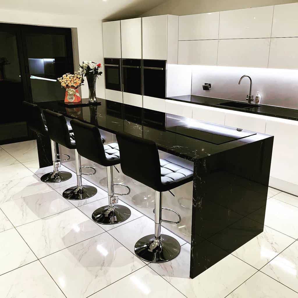 modern white kitchen black marble island four black seats white floor tiles 