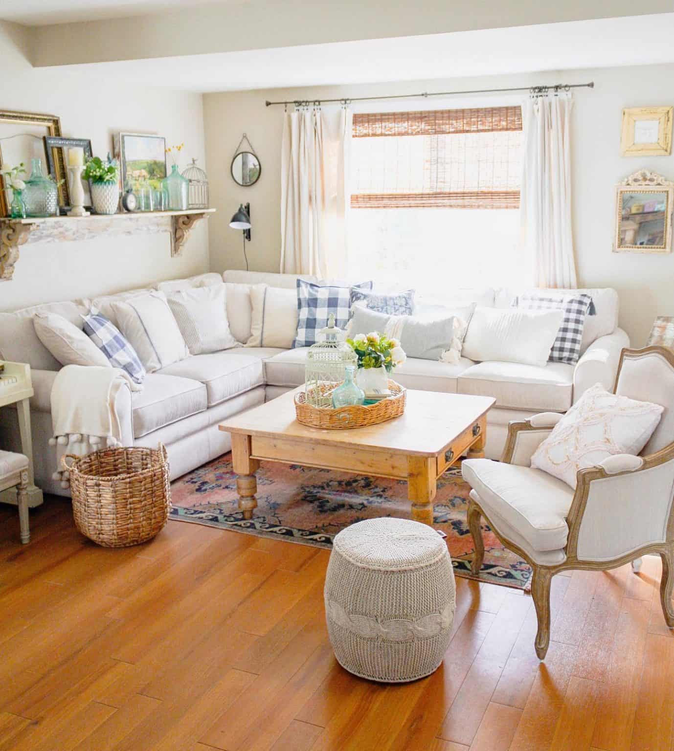 Country-style living room with beige sectional, wooden coffee table, and rustic decor accents.