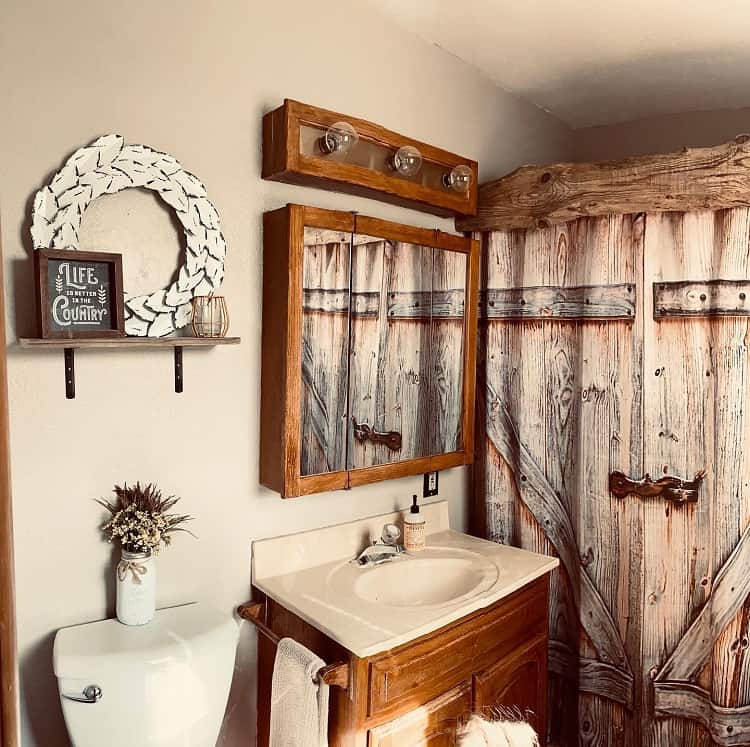 Farmhouse-style bathroom with wood accents, a vintage mirror, and a decorative sign on the wall