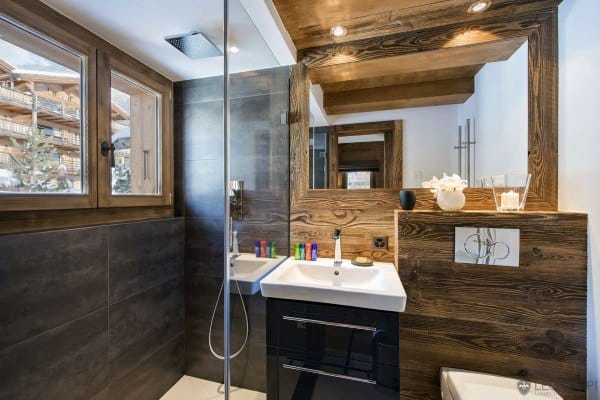 Modern bathroom with wooden accents, shower, sink, and large window with mountain view