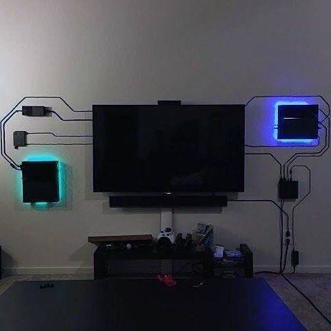 Wall-mounted TV with glowing green and blue backlit boxes and cable art design