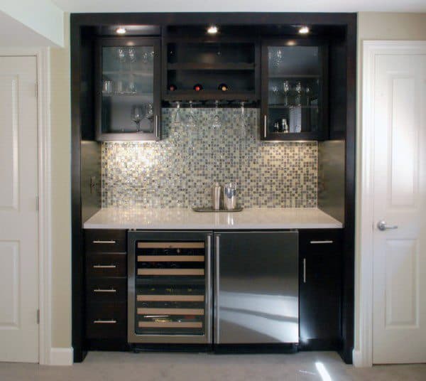 Mini bar with dark cabinets, mosaic tile backsplash, wine fridge, and stainless steel appliances.