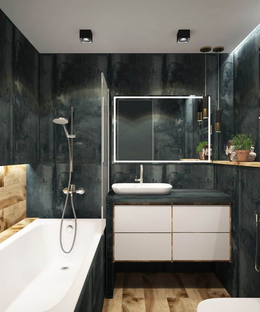 Luxury small bathroom with black tiles, white bathtub, and wooden accents.