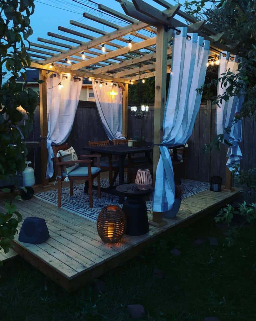 wood deck pattern rug gazebo white curtains hanging lights