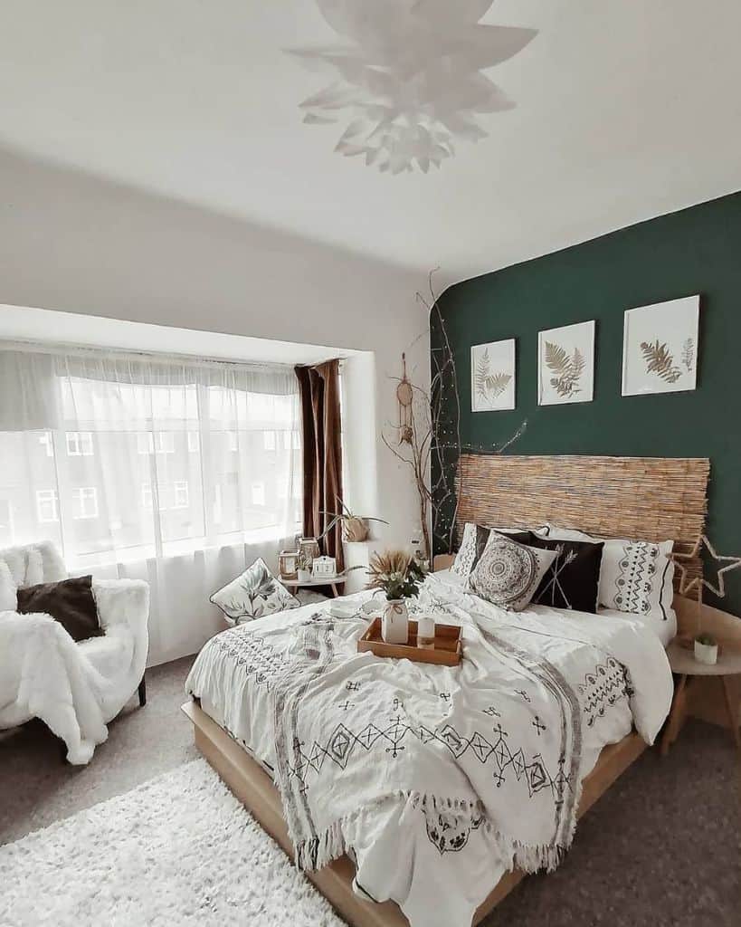 Boho bedroom with green accent wall, woven headboard, cozy textiles, and natural decor accents.