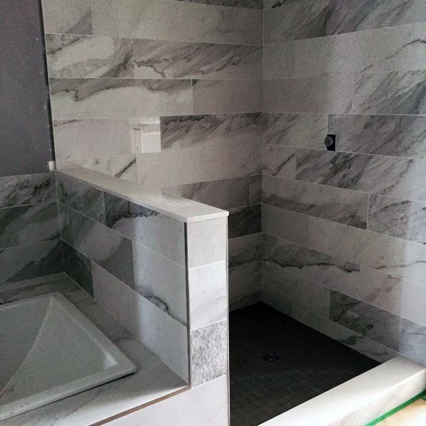 Modern bathroom with a grey marble-tiled shower and adjacent tub