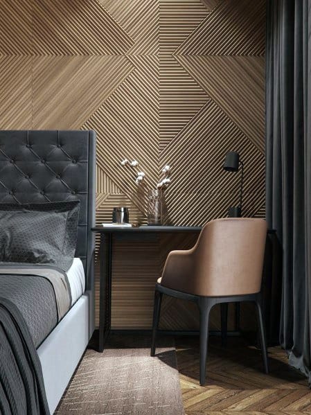 Modern bedroom with abstract wood paneling tufted bed black desk and beige chair.