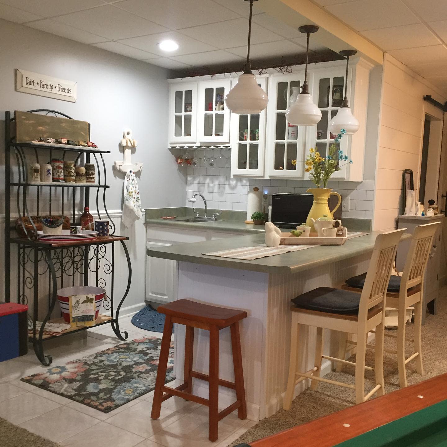 Rustic kitchen with farmhouse decor, bar seating, and glass-front cabinets.