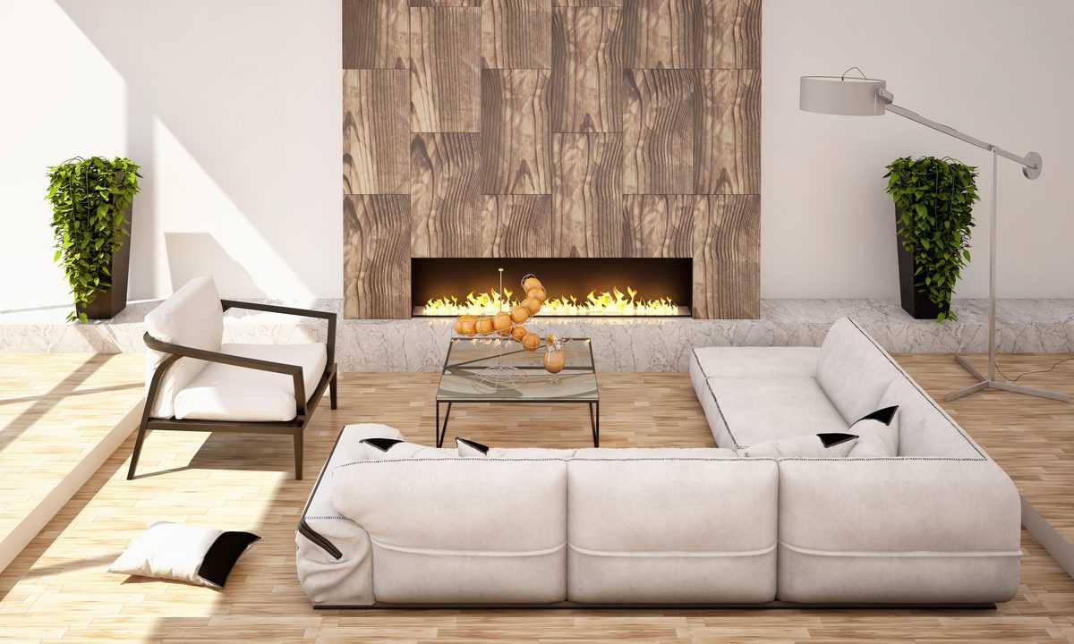 Recessed electric fireplace on a wood-accent wall with modern white sectional and glass table.