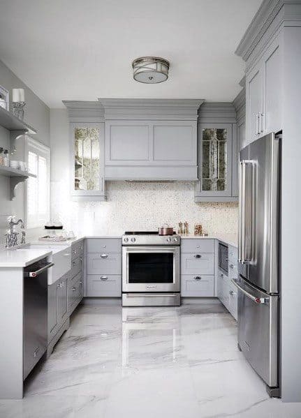 Sleek kitchen with polished concrete flooring, grey cabinetry, and modern stainless steel appliances