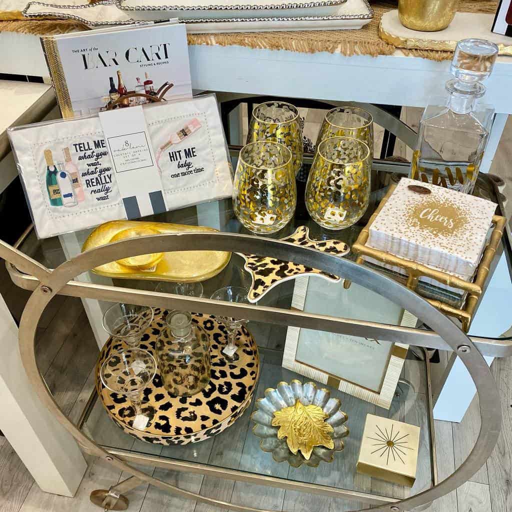 Gold bar cart with leopard print decor, cocktail glasses, and festive napkins.